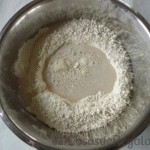 01 - Juntamos la harina y la sal en un bol y añadimos el agua con la levadura