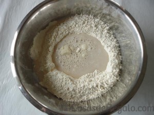 01 - Juntamos la harina y la sal en un bol y añadimos el agua con la levadura
