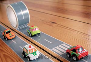 Coche de juguete con cinta adhesiva para tender carreteras